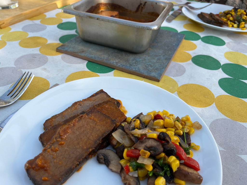 sliced brisket served with a corn, mushroom salad