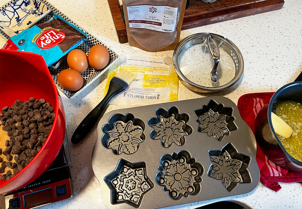 Ingredients for a flourless chocolate cake: cocoa, butter, sugar, dark chocolate chips, eggs